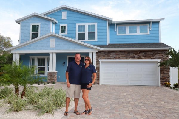 WinWay Homes 2-Story Coastal Home with Blue Siding, Stone Base, White Trim, Covered Porch & Attached Garage