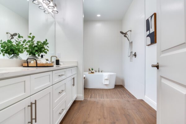 WinWay Homes Primary Bathroom with Freestanding Tub, White Vanity, Wood-Look Flooring & Bright Modern Finishes