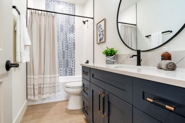 WinWay Homes Bathroom with White Vanity, Shower with Wall Mosaic, Sheer Shower Curtain, , Round Mirror & Black Fixtures