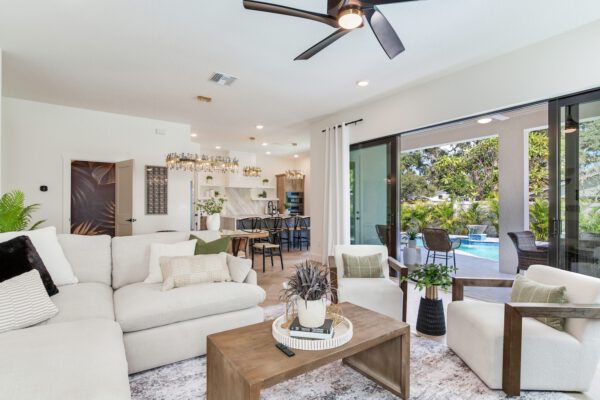 WinWay Homes Living Room with Pool View, Sliding Glass Doors, Open Dining Area & Neutral Modern Furnishings