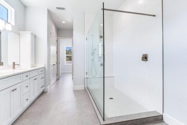WinWay Homes Primary Bathroom with Walk-In Shower, White Vanity, Light Tile Flooring & Bright Contemporary Design