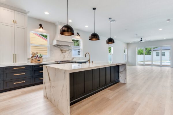 WinWay Homes Kitchen and Living Area with Waterfall Island, Black Pendants, Marble-Look Finishes & Open Layout