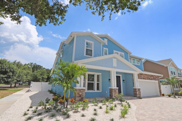 New WinWay Custom Home with 2 Stories, Blue Siding and White Trim, Stone Details, and New Landscaping with Palm Tree