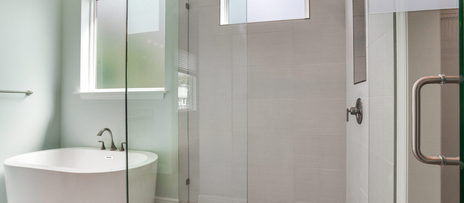 Spa-Inspired Master Bath in Neutral Tones with Glass Walk-in Shower and Separate Freestanding Tub with Window
