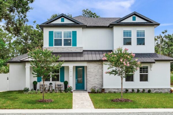 WinWay Homes 2-Story Coastal Home with Covered Front Porch, Teal Front Door, Teal Shutters, white exterior, stone accents & attached garages