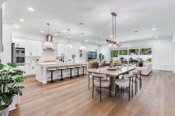 WinWay Homes Open Kitchen, Dining and Living Area with large island, light wood-look flooring, modern lighting & open-concept layout