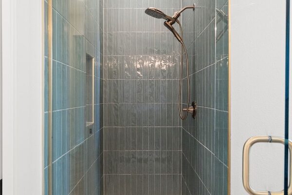 WinWay Homes Walk-In Shower with Green Tile Walls, Glass Enclosure, Gold Hardware, White Shower Floor & Modern Fixtures