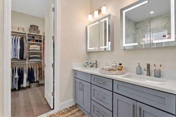 WinWay Homes Master Bath with Double Vanity and Makeup Mirrors, Sconce Lighting, Gray Cabinetry, Wood-Style Flooring and Walk-in Closet with Built-in Shelving, Hanging Racks