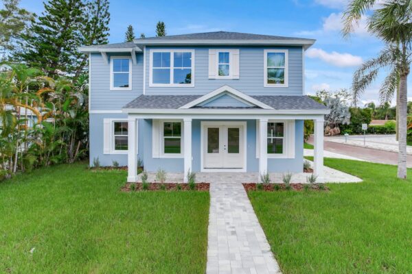 WinWay 2-Story Coastal Home Exterior with Pale Blue Siding, White Trim, White Columns, and Tiled Walkway