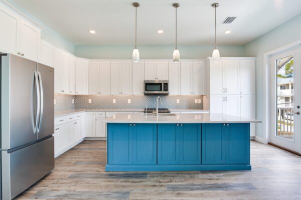 WinWay Homes Kitchen with Teal Blue Island, White Cabinetry, Woven Pendant Lights & Stainless Appliances