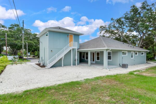 WinWay Homes Pale Gray 1-Story Home with White Trim and 2-Story Structure with Railing and Yellow Door