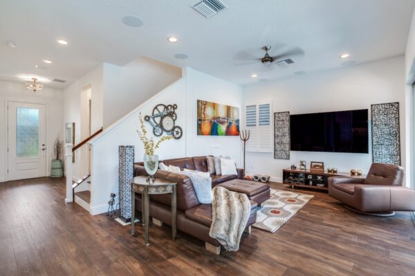 Open Living Area with Wood Plank Flooring, Neutral Tones, Recessed Lighting, Staircase and Widescreen Television with Accent Framing