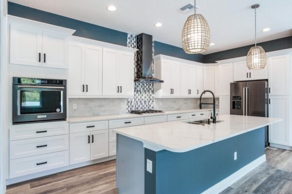WinWay Homes Kitchen with Blue Island, White Cabinetry, Woven Pendant Lights & Stainless Appliances