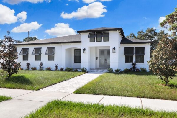 WinWay Homes Coastal Style Home in White Stucco, Black Roof and Trim with Multiple Open-Screen Windows and Gray French Doors.