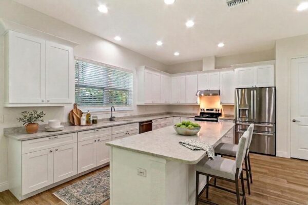WinWay Homes Kitchen with White Cabinetry, Center Island, Neutral Finishes & Stainless Appliances