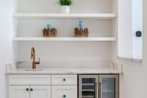 WinWay Homes Wet Bar with open shelving, beverage fridge, white cabinetry, quartz countertop & gold faucet