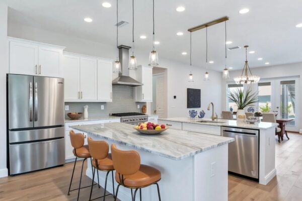 WinWay Homes Open Concept Kitchen with Dural Kitchen Islands, Leather Bar Stools, Marble Countertops, Food Prep Area, and Dramatic Pendant Lighting