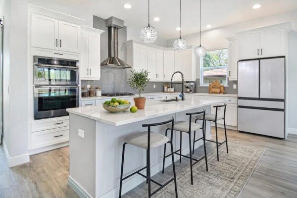 WinWay Homes Modern Kitchen With Large Island, White Cabinetry, Pendant Lighting, Stainless Appliances & Light Tile Flooring