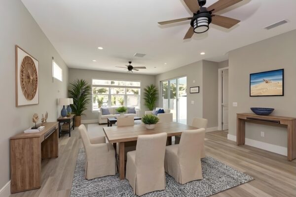 WinWay Homes Open Living and Dining Area with neutral seating, light wood-look flooring, ceiling fan, console tables & bright coastal-style layout