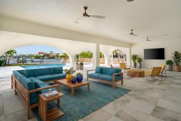 WinWay Homes Covered Outdoor Living Area with Lounge Seating, Arched Openings, Tile Flooring, Ceiling Fans & Water View