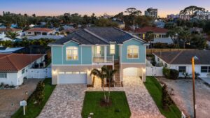 Custom Elevated Home Front Aerial View at Night with Lighting and Expansive Driveway at Sunset in St. Petersburg, Florida