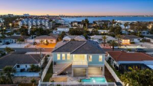 Aerial View of the Back of a Beautiful Elevated Home at Night with a Pool by WinWay Homes in St. Petersburg, Florida