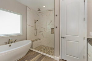 WinWay Homes Spa Style Master Bathroom with Freestanding Tub and Glassed-In Shower with Bench in Neutral Tones