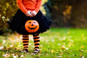 Girl in Halloween Costume Holding Jack O Lantern Container for Trick or Treating in Northeast Neighborhood of St. Petersburg